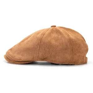 Detail of a dark brown suede newsboy cap featuring multi-panel stitching and top button