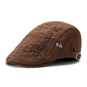 Brown cotton flat cap with squirrel embroidery and metallic badge shown from side angle