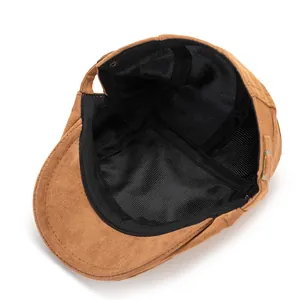 Dettaglio cappello piatto in pelle scamosciata marrone con fodera e fibbia in metallo