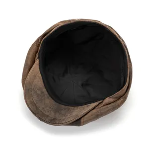 Detail of vintage brown newsboy cap with distressed texture and inner fashion label