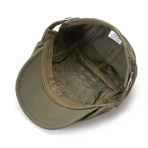 Detail view of military green cotton flat cap interior with adjustable buckle and label