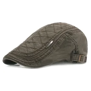 Detail of olive brown beret featuring diamond quilted stitching and adjustable metal buckle