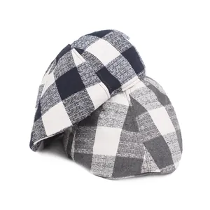 Close-up of black and white plaid linen newsboy cap with detailed woven fabric texture
