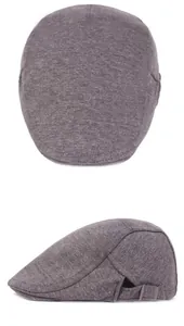 Detail of dark grey wool beret showing the metallic side buckle and knit fabric texture