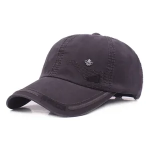 Detail of grey washed cotton cap with side wave embroidery and metal maple leaf badge