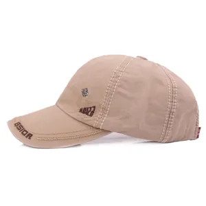 Khaki cotton baseball cap with letter embroidery and leaf brooch in a side view