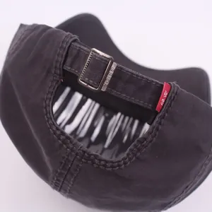 Close-up of black cotton baseball cap with vintage metal buckle and red label detail