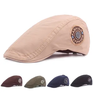Detail view of cotton flat cap with embroidered side badge and metal star buckle accent