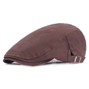 Détail du tissu à chevrons marron foncé et boucle métallique réglable sur une casquette