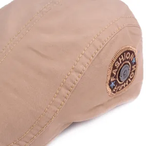 Macro shot of khaki cotton flat cap featuring embroidered fashion sports badge detail