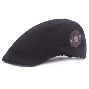Classic black cotton beret cap with fashion patch detail on a pure white background