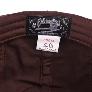 Interior detail of a dark brown cotton beret showing neat stitching and 58cm size label