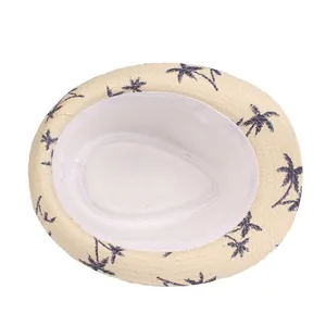 Beige straw sun hat with navy palm tree prints and sweatband on white background