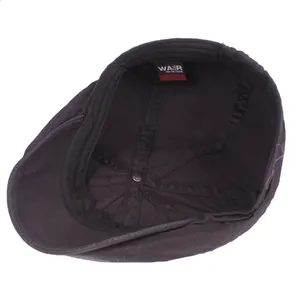 Inside view of a cotton flat cap showing lining stitching and metal rivet detail