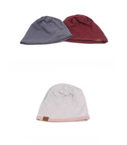 Detail of double-layer knit beanies with F & S leather logo in gray, burgundy and blue