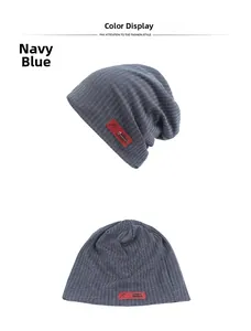 Detailed close-up of navy blue knit beanie with vertical ribbed texture and red label