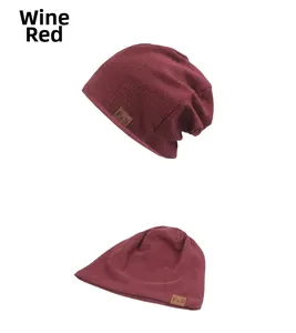 Macro shot of wine red knitted beanie showing ribbed texture and F&S leather patch detail