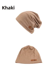 Detail view of khaki ribbed knit beanie showing soft fabric texture and leather patch