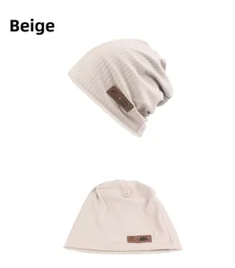 Detail view of beige ribbed knit beanie featuring premium brown leather fishbone patch