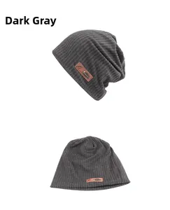 Detail of dark grey knit beanie showing vertical texture and brown leather brand label