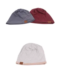 Close-up of ribbed knit beanies in dark grey, burgundy and light pink with leather labels
