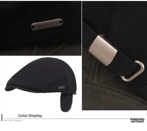 Close-up detail of winter beret cap showing metal logo plate and adjustable buckle strap