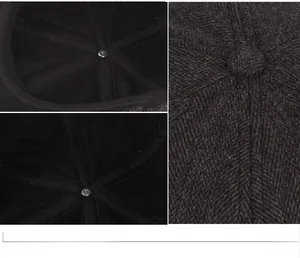 Detail view of the herringbone wool texture and inner lining of the dark gray baker boy hat