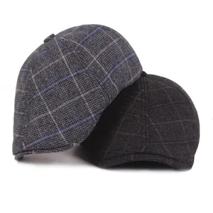 Detailed view of grey and brown plaid berets showing the thick autumn wool texture