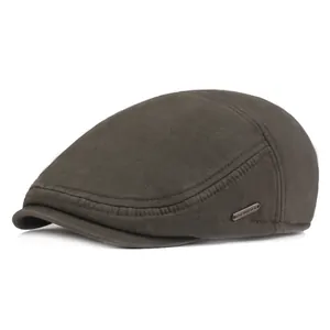 Close-up of a warm olive winter newsboy cap featuring detailed stitching and metal tag