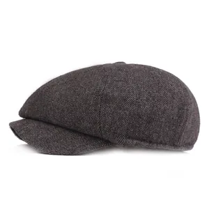 Detail of grey herringbone newsboy cap fabric texture and classic stiff brim design