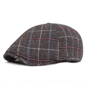 Detailed macro shot of vintage plaid newsboy cap showing grey woven fabric texture
