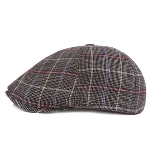 Close-up of thick plaid newsboy cap featuring vintage red and grey checkered wool texture