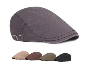 Detail of cotton flat cap featuring diamond quilted stitching and metal buckle