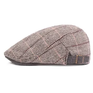 Detail of grey herringbone tweed flat cap with red plaid and metal adjustment buckle
