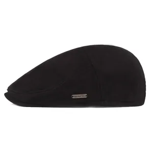 Close-up of black winter newsboy cap featuring neat stitching and metal logo detail