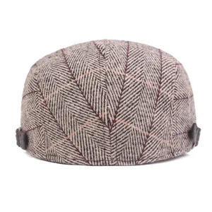Close-up of retro herringbone pattern and buckle detail on this wool flat cap