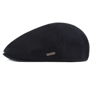 Detail view of the black cotton flat cap featuring a metallic OKSDFOX brand logo on the side