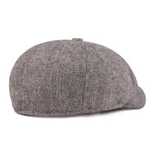 Close-up of gray herringbone fabric texture on a vintage newsboy cap for men and women