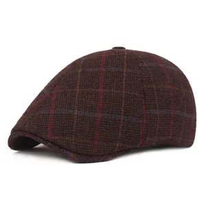 Close-up of thick wool blend fabric on dark brown plaid newsboy cap for winter