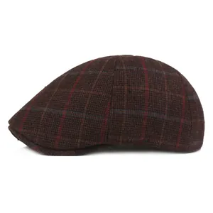 Close-up detail of dark brown plaid fabric on a warm winter newsboy flat cap