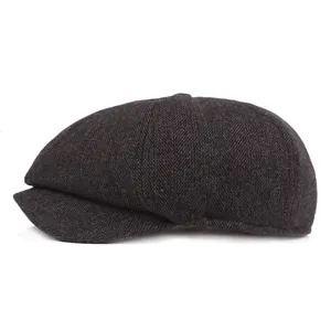 Detailed view of dark grey herringbone newsboy cap with classic thick textured wool fabric