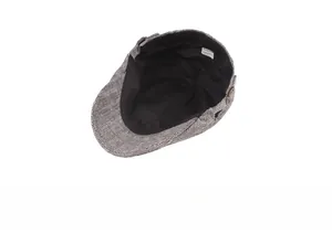 Detailed inner view of herringbone newsboy cap showing black fabric lining and care label