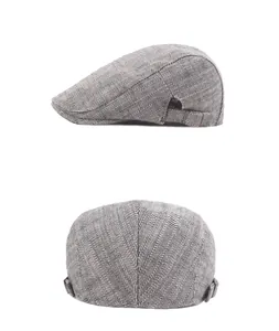 Detail of grey herringbone flat cap featuring adjustable metal buckle and woven texture
