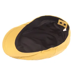 Detailed interior of ginger yellow flat cap showing black lining and snap button strap
