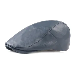 Détail de la casquette plate en cuir bleu-gris avec texture grainée et coutures précises