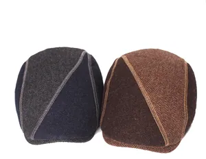 Detail of wool blend herringbone newsboy caps with vintage patchwork and stitching