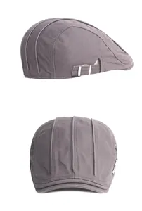 Detail view of dark grey flat cap showing side adjustment buckle and vertical stitching