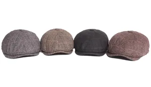 Detailed view of four plaid newsboy caps in various colors with thick wool-blend texture