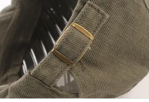 Détail de la boucle métallique réglable et du tissu en sergé sur le béret vert militaire