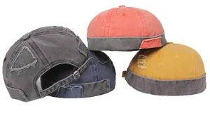 Detail of washed cotton brimless caps with vintage distressed patches and metal buckle